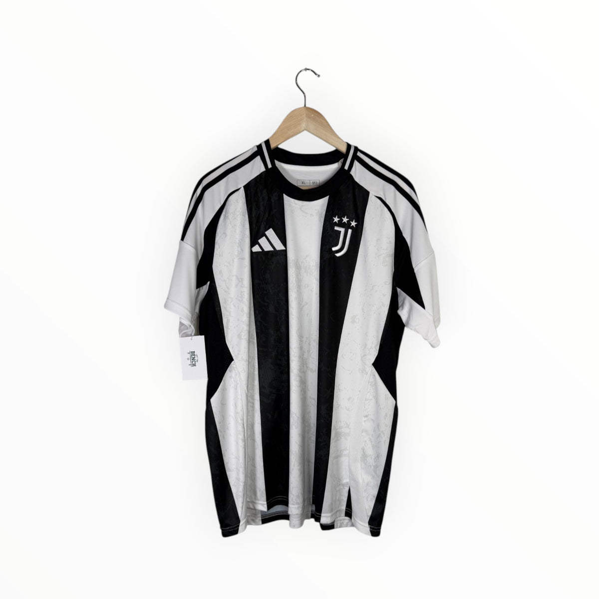 A vintage Adidas Juventus home soccer jersey with black and white vertical stripes, hanging on a wooden hanger against a plain white background.