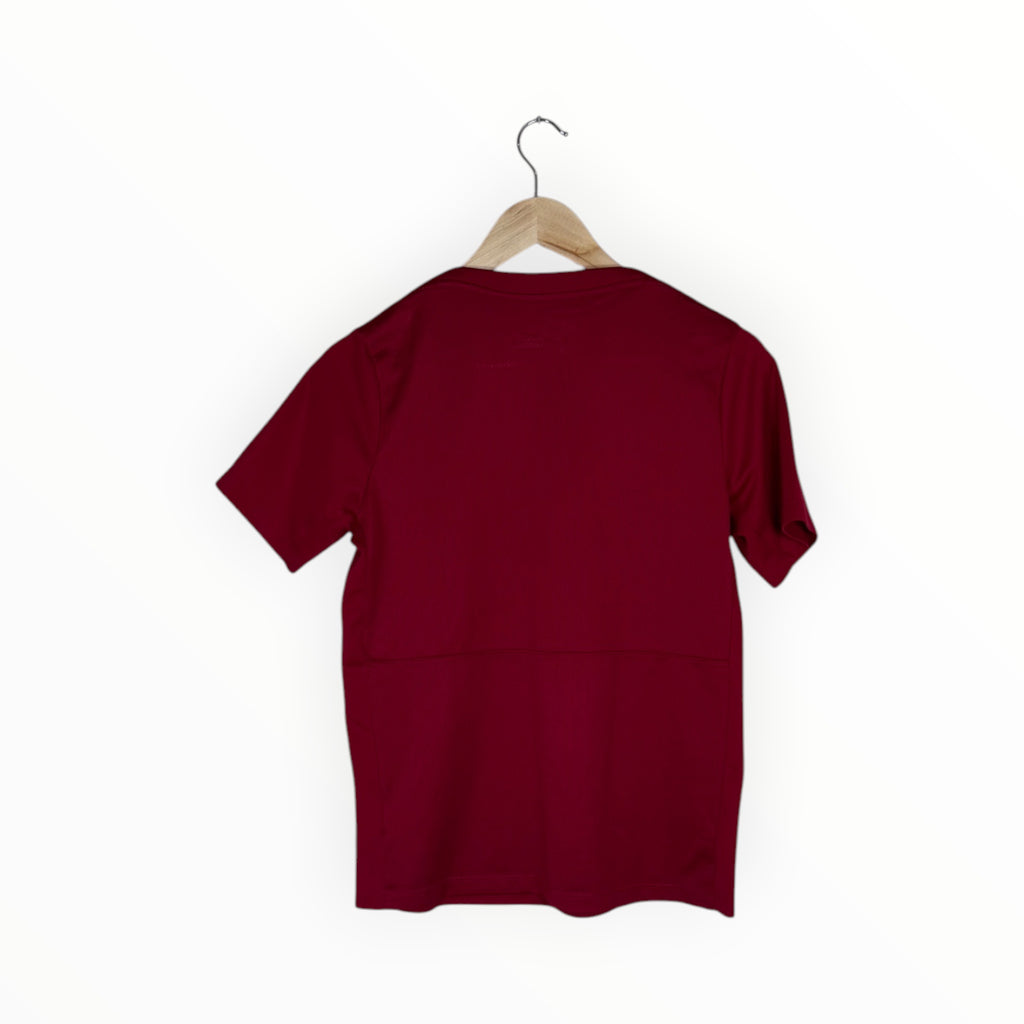 A short-sleeve crewneck t-shirt in deep burgundy, shown from the back hanging on a wooden hanger against a plain white background.