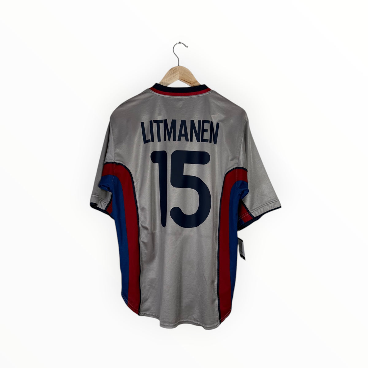 A gray soccer jersey with 'LITMANEN' and the number '15' printed in navy blue on the back, hanging on a wooden hanger against a white background. The jersey features red and blue side panels.