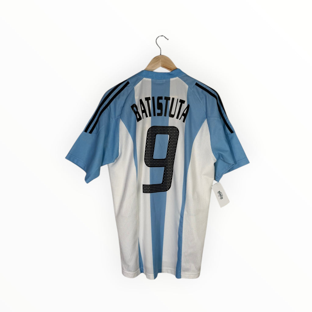 A light blue and white striped Argentina soccer jersey with 'BATISTUTA' and the number '9' on the back, hanging on a wooden hanger against a white background.