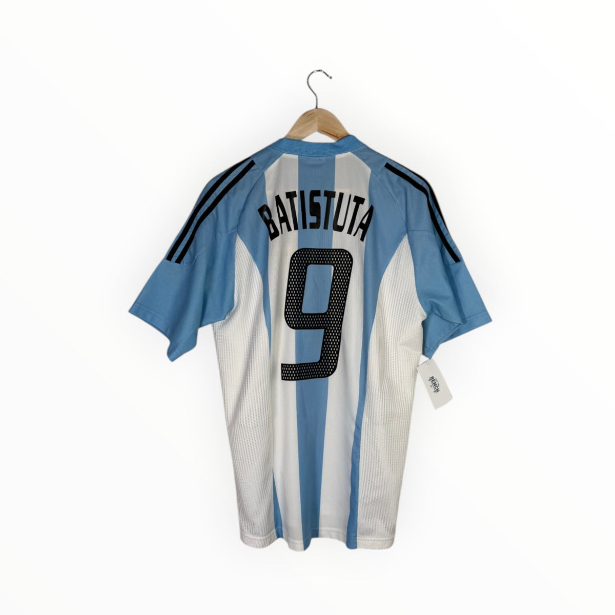 A light blue and white striped Argentina soccer jersey with 'BATISTUTA' and the number '9' on the back, hanging on a wooden hanger against a white background.