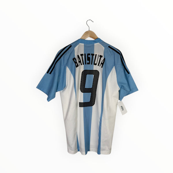 A light blue and white striped Argentina soccer jersey with 'BATISTUTA' and the number '9' on the back, hanging on a wooden hanger against a white background.