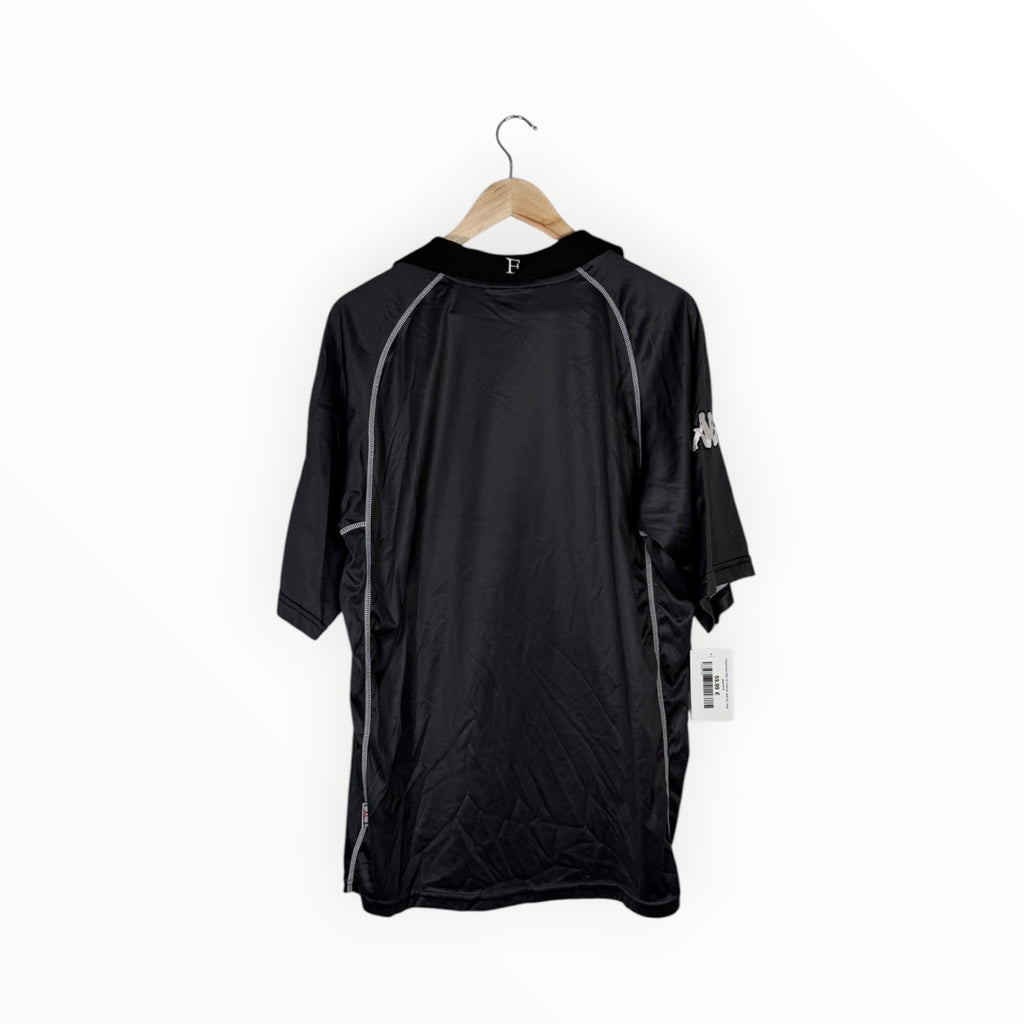 A black hooded athletic jacket with gray piping details and a white logo on the sleeve, hanging on a wooden hanger against a plain white background.