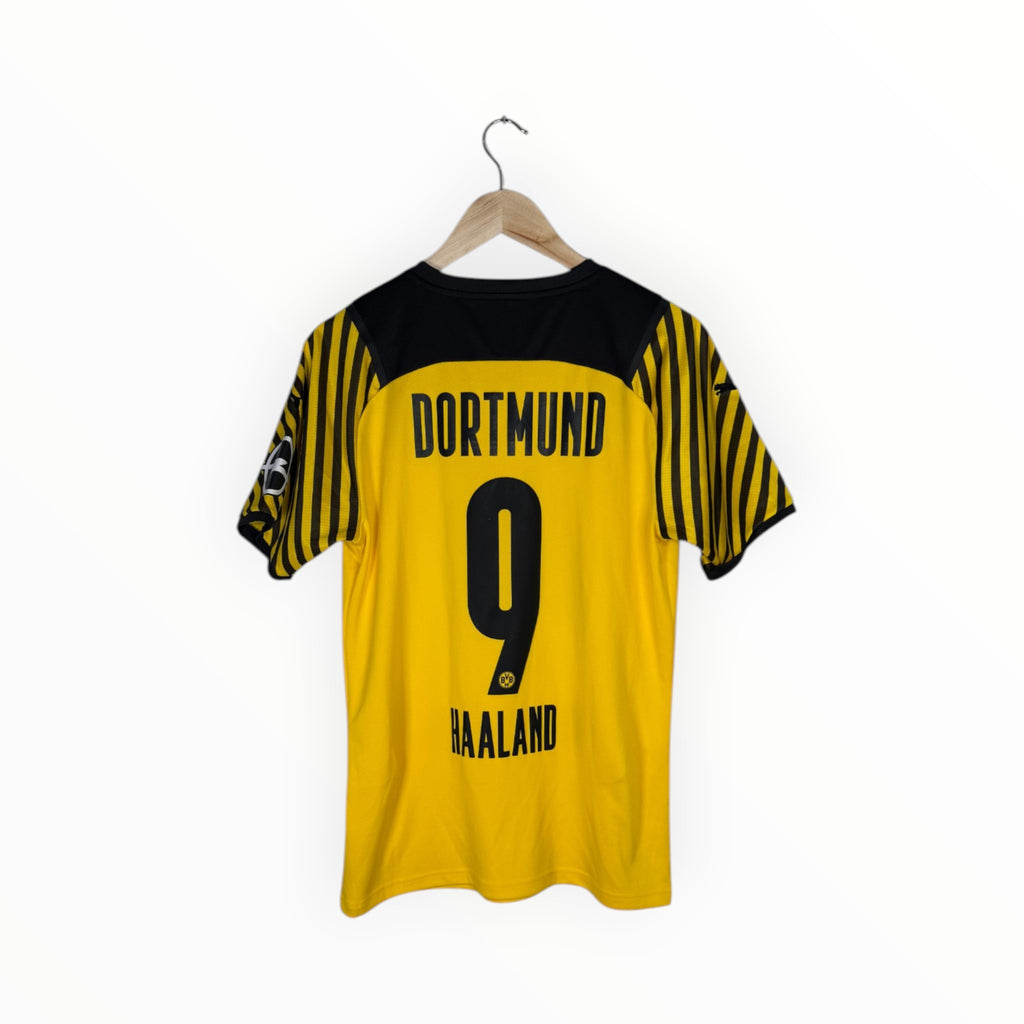 A yellow and black Borussia Dortmund soccer jersey with 'DORTMUND', the number '9', and 'HAALAND' printed on the back, hanging on a wooden hanger against a white background.
