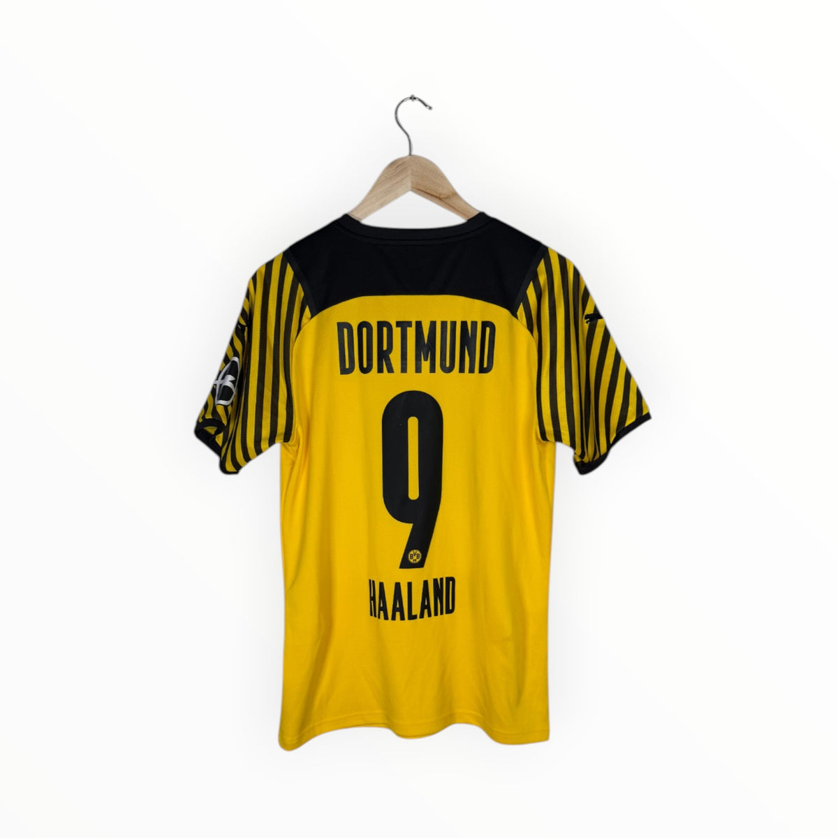 A yellow and black Borussia Dortmund soccer jersey with 'DORTMUND', the number '9', and 'HAALAND' printed on the back, hanging on a wooden hanger against a white background.