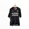 A vintage black Kappa soccer jersey for SC Rotterdam, hanging on a wooden hanger against a plain white background. The jersey features white text reading 'STAD ROTTERDAM VEZEKERING' across the chest, with the Kappa logo on the right chest and the SC Rotterdam crest on the left.