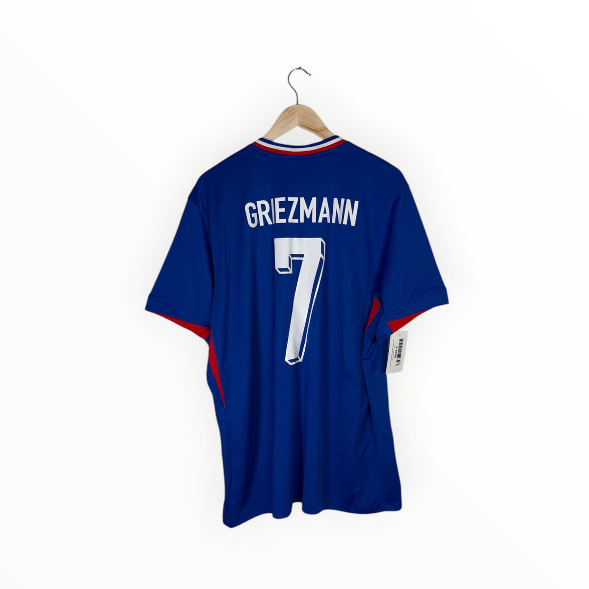 A royal blue soccer jersey with 'GREZMANN' and the number '7' printed in white on the back, hanging on a wooden hanger against a plain white background.