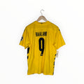 A yellow Borussia Dortmund soccer jersey with 'HAALAND' and the number '9' printed in black on the back, hanging on a wooden hanger against a white background.