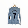 A light blue long-sleeve soccer jersey hanging on a wooden hanger against a white background, showing the back with 'JOÃO FÉLIX' and the number 7 printed in black.