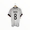 A white Germany national team soccer jersey with 'KROOS' and the number '8' printed on the back, hanging on a wooden hanger against a white background.
