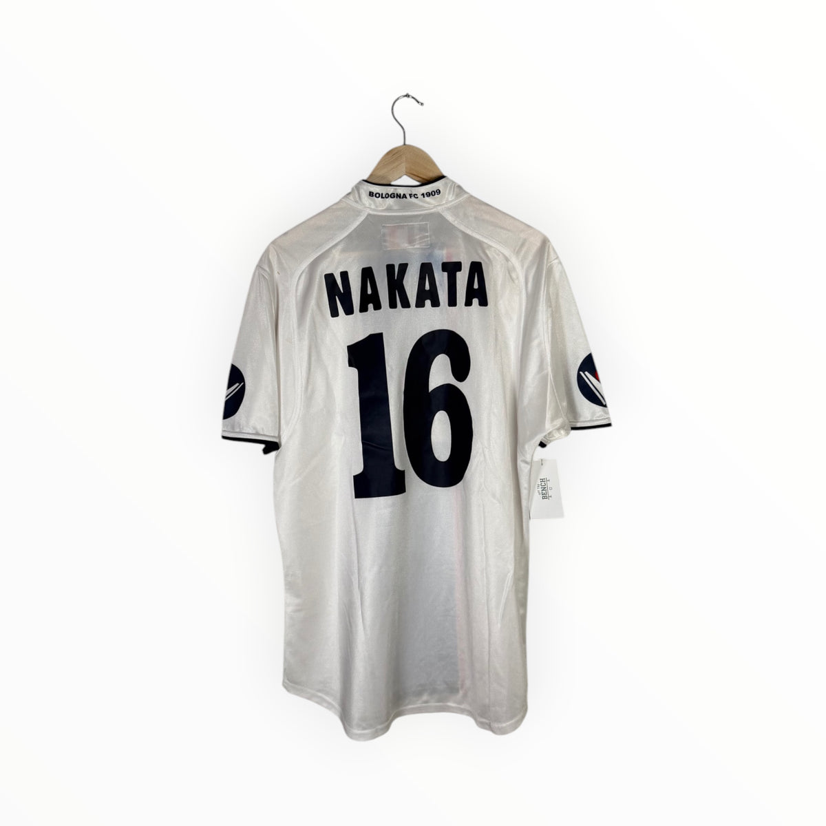 A white short-sleeve sports jersey hanging on a wooden hanger against a plain white background. The back of the jersey features the name 'NAKATA' and the number '16' in black.