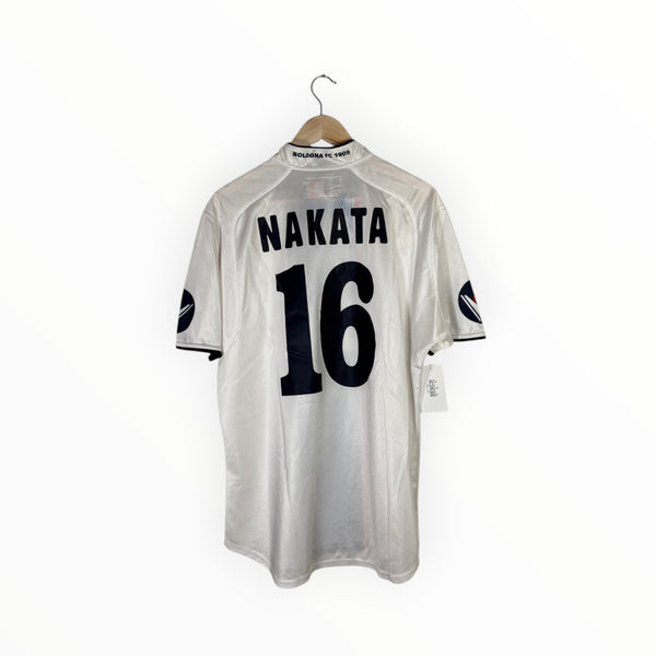 A white short-sleeve sports jersey hanging on a wooden hanger against a plain white background. The back of the jersey features the name 'NAKATA' and the number '16' in black.
