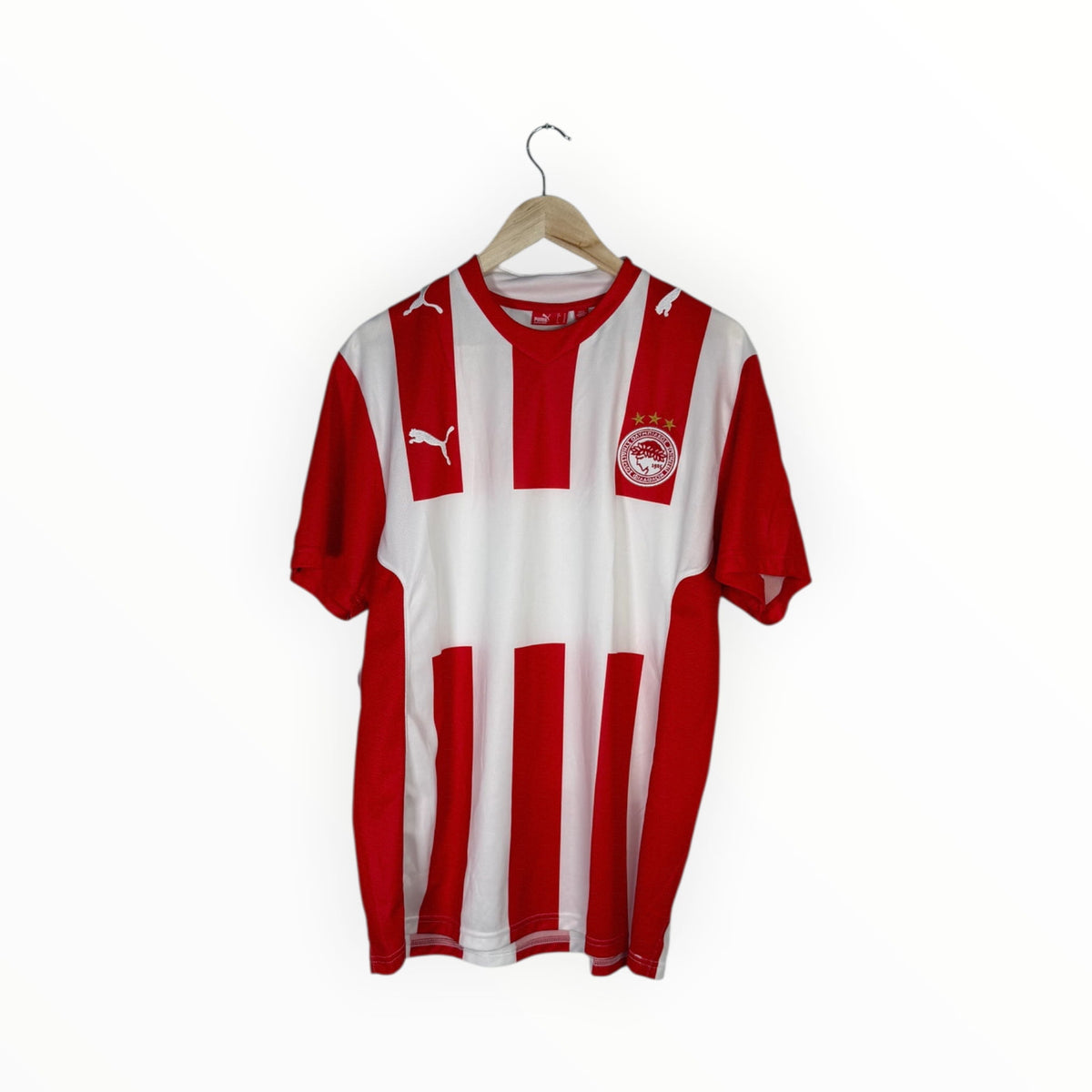 A red and white vertically striped Puma football jersey hanging on a wooden hanger against a plain white background.