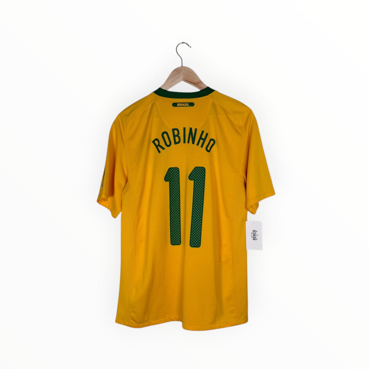 A yellow Brazil soccer jersey with 'ROBINHO' and the number '11' printed in green on the back, hanging on a wooden hanger against a white background.