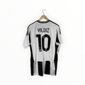 A white and black striped Juventus soccer jersey with 'YILDIZ 10' printed on the back, hanging on a wooden hanger against a white background.